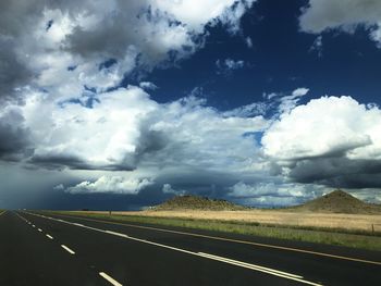 Scenic view of road against cloudy sky