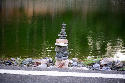 Stack of stones on rock by lake