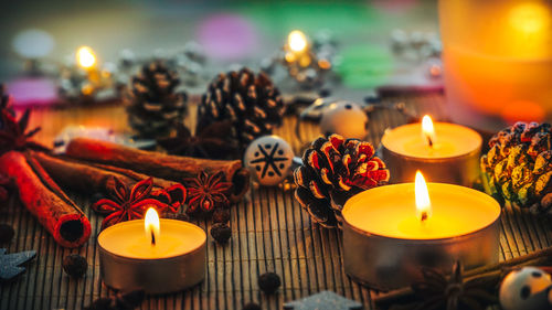 Close-up of burning tea lights decorations and spices on table