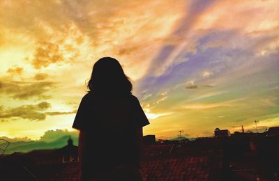 Silhouette of woman looking at sunset