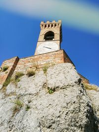 Low angle view of bell tower against blue sky