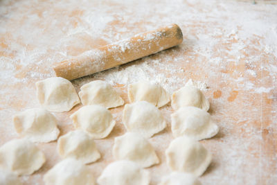 Close-up of food and rolling pin with flour on table