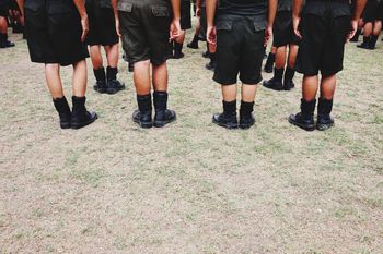 Low section of children wearing uniforms standing on land