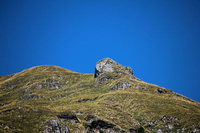 Low angle view of mountain against clear blue sky