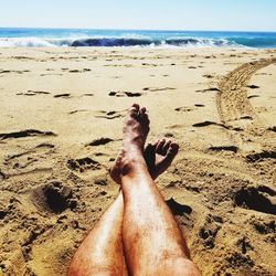 Low section of person relaxing on beach