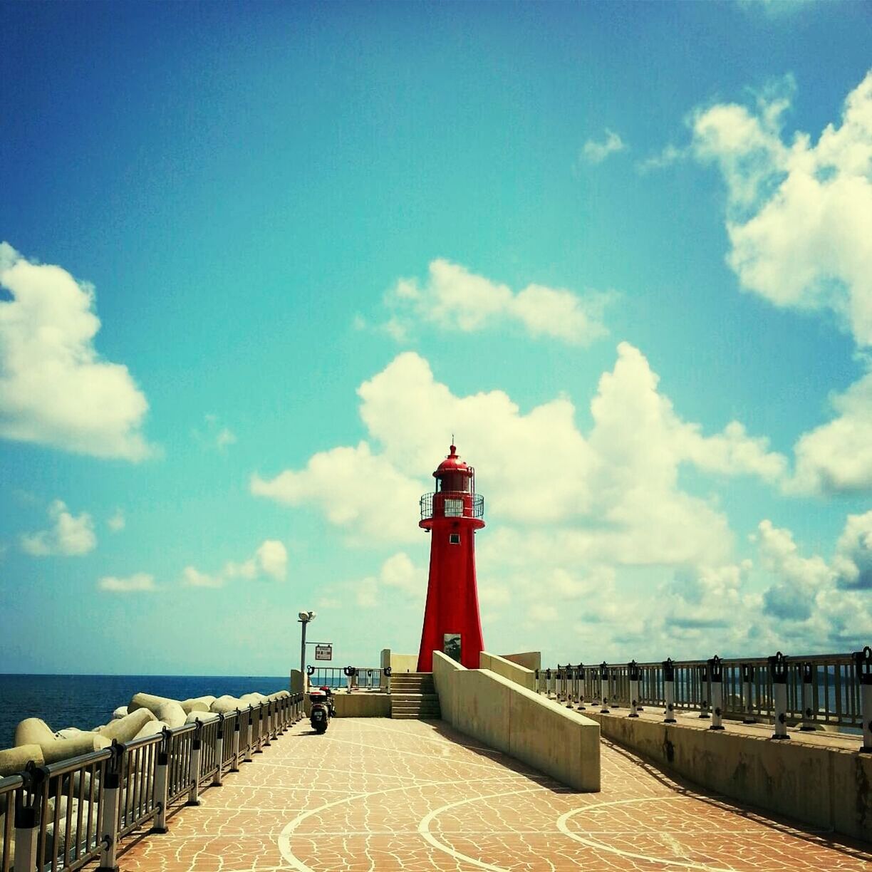 sea, sky, lighthouse, horizon over water, water, built structure, guidance, railing, protection, architecture, safety, cloud - sky, security, direction, beach, red, tranquility, cloud, pier, tranquil scene
