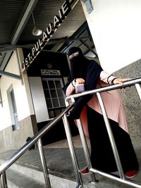 Low angle view of man standing on railing