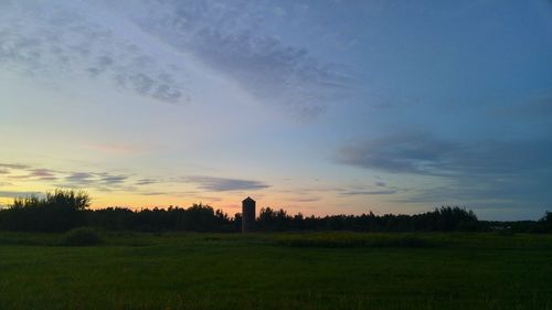 Scenic view of grassy field against cloudy sky