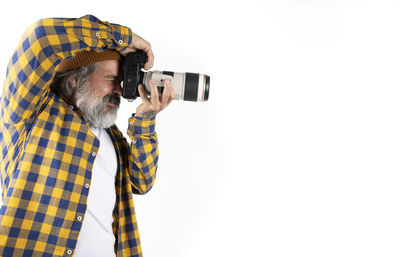 Rear view of man holding camera against white background