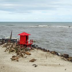 Lifeguard hut on beach against sky