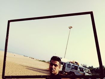 Man holding camera against clear sky