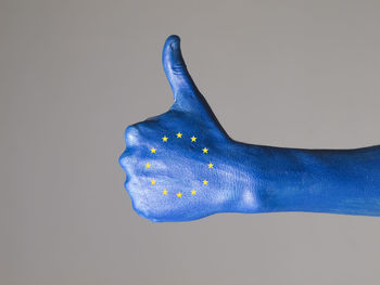 Close-up of human hand against blue background