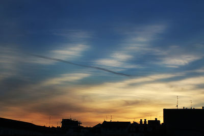 Low angle view of silhouette buildings against sky