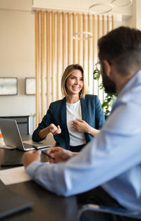 Glad businesspeople discussing work together