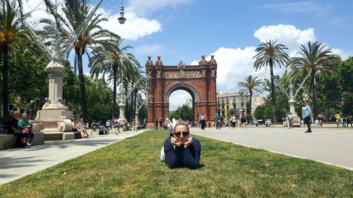 Woman lying down against arc de triomf in city