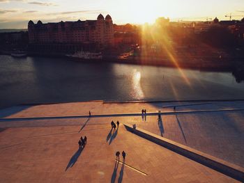 High angle view of people by river in city against sky