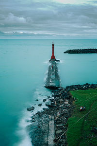A red lighthouse, a man in red and a red motorbike