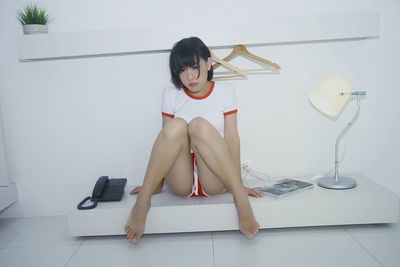 Portrait of woman sitting on tiled floor at home