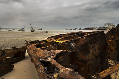 Close-up of ship wreak on beach against sky