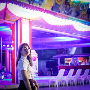 Portrait of young woman standing in amusement park