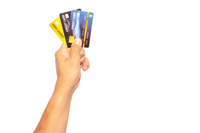 Close-up of woman hand holding paper over white background