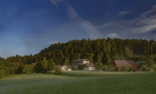 Scenic view of trees and houses against sky