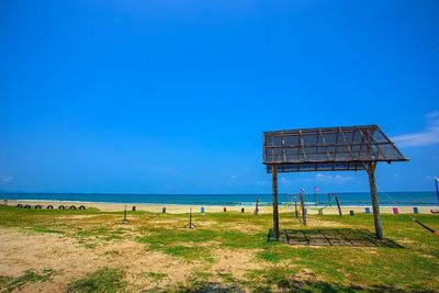 Lifeguard hut on beach against blue sky