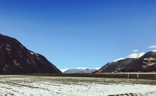 Scenic view of snowcapped mountains against clear blue sky