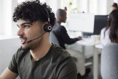 Man wearing headset using desktop pc in office
