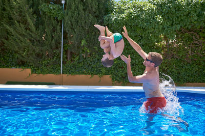 Summer vacation. father and son play in a pool.