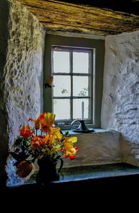 Flower vase against window of house