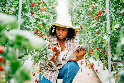 Portrait of smiling young woman standing against plants