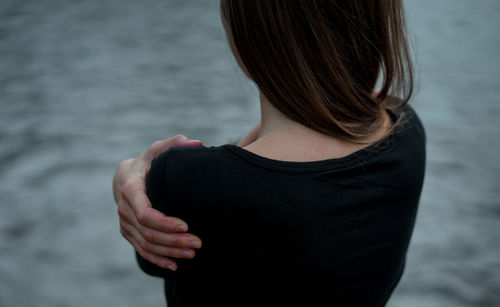 Rear view of woman standing against sea