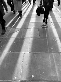 Low section of people walking on tiled floor