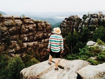 Rear view of man standing on rocks