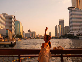 Side view of woman sitting on city