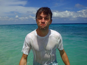 Portrait of man standing in sea against sky