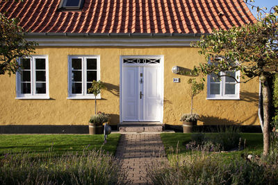 View of warm yellow building with front garden