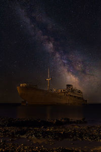 Scenic view of illuminated sea against sky at night