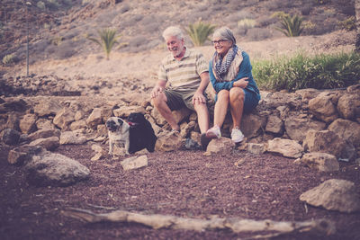 Senior couple with dogs on rocks