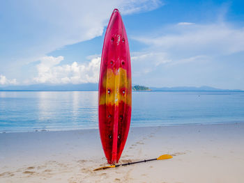 Red umbrella on beach against sea against sky