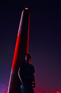 Low angle view of man standing against sky at night