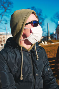 Midsection of man wearing sunglasses standing outdoors during winter
