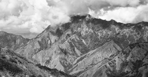 Scenic view of mountain range against cloudy sky