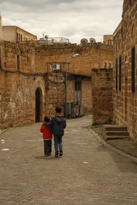 Rear view of man and woman walking on building