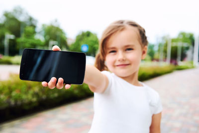 Portrait of smiling girl holding camera