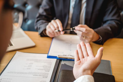 Midsection of couple holding hands on table