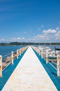 View of pier over sea against blue sky