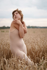 Woman standing on field against sky