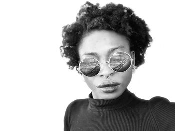 Portrait of teenage girl wearing sunglasses against white background